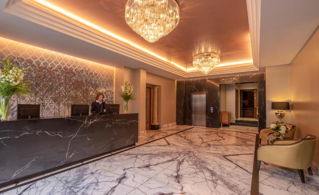 a lobby of a hotel with a woman sitting at a desk at Eyre Square Hotel in Galway