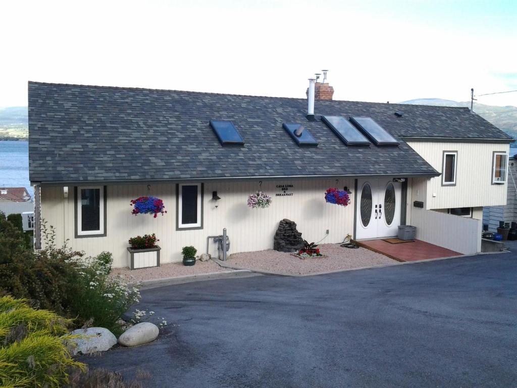 a white house with solar panels on the roof at Casa Loma BnB in West Kelowna