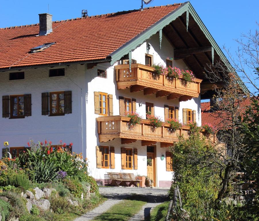 Una casa blanca con balcones y flores. en Jaklhof, en Frasdorf