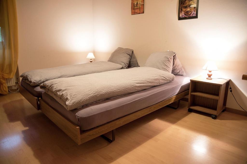 Una cama en una habitación con dos lámparas. en La Légende, en Les Bois