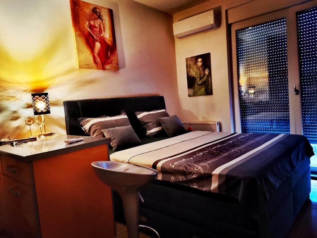 1 dormitorio con cama, escritorio y ventana en Apartment CITY, en Doboj