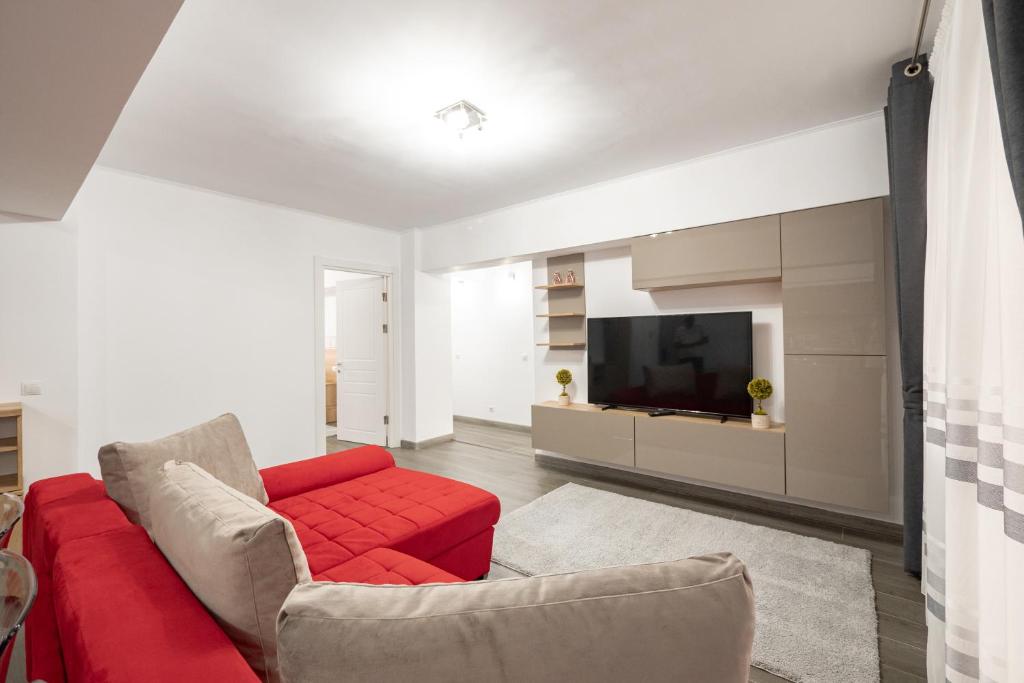 a living room with a red couch and a tv at Luxury Ultracentral in Piteşti