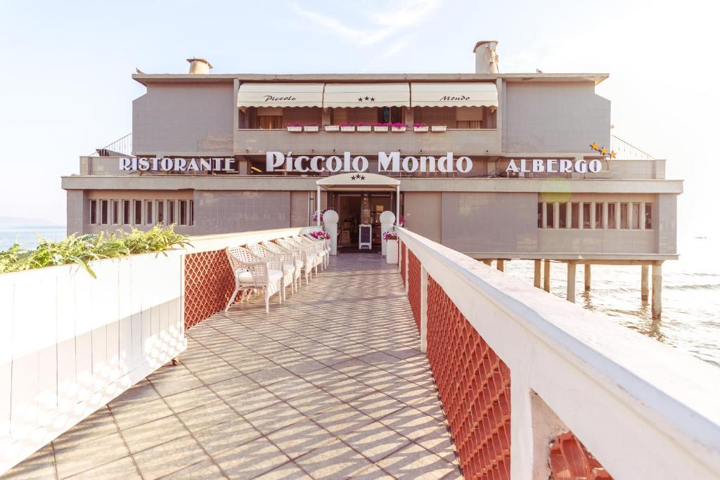 - un bâtiment sur une jetée à côté de l'eau dans l'établissement Piccolo Mondo Hotel, à Follonica