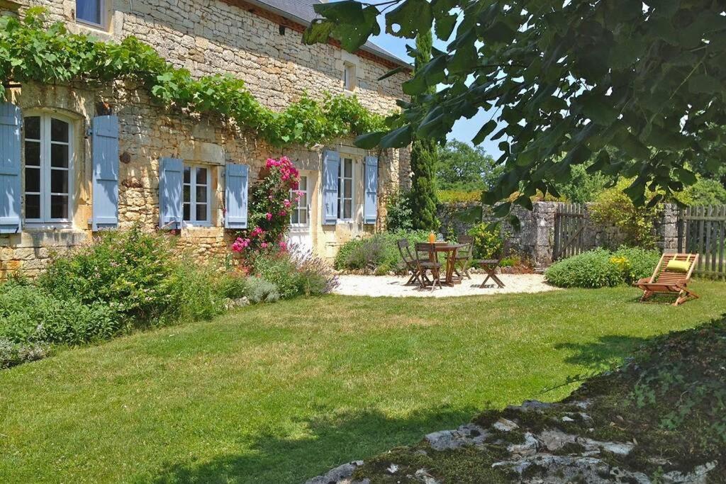 ein Steinhaus mit einem Picknicktisch im Hof in der Unterkunft Gîte écologique en vallée de la Dordogne Lotoise in Gignac