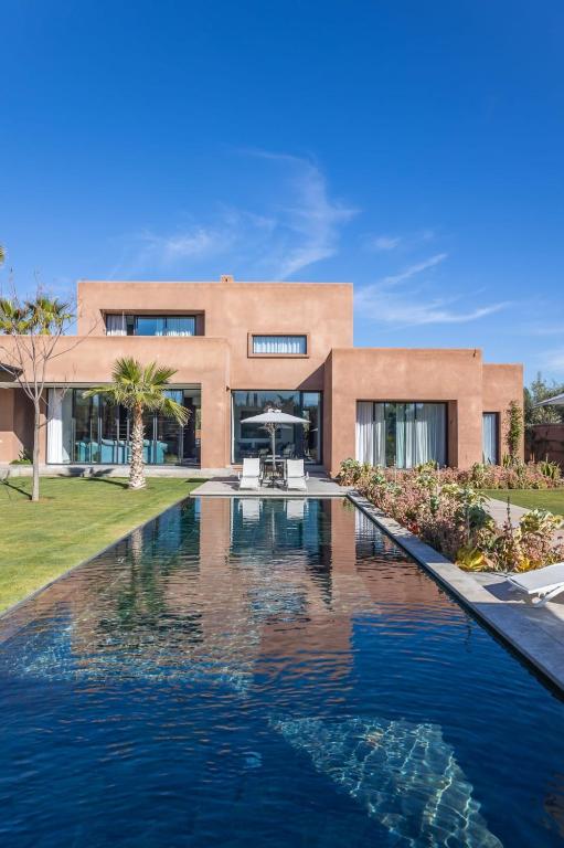 a house with a swimming pool in front of a house at Villa familiale aux portes de Marrakech in Marrakesh