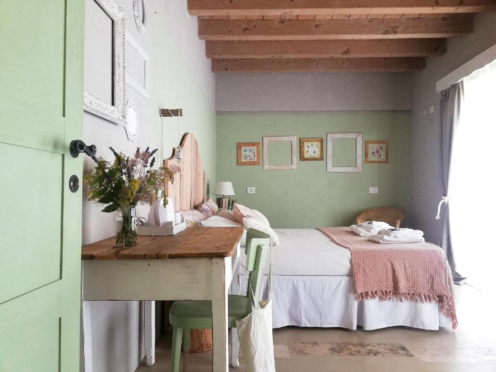 a bedroom with a bed and a desk with a table at B&B Cà Montemezzano in Verona