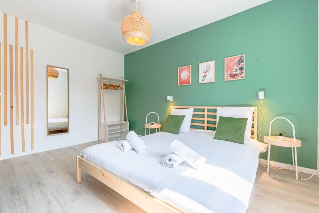 1 dormitorio con 1 cama blanca grande y paredes azules en matcha cerisier - matcha home Serémange, en Serémange-Erzange