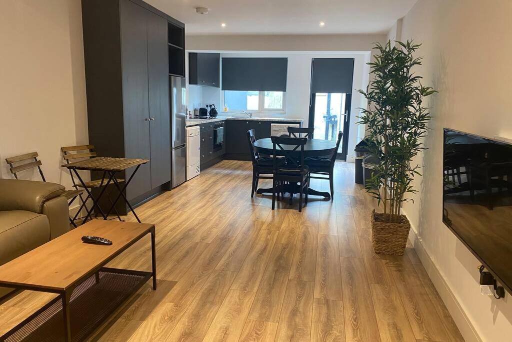 a living room with a table and chairs and a kitchen at Apt 3 Silver Spruce - Killarney Town Free Parking in Killarney