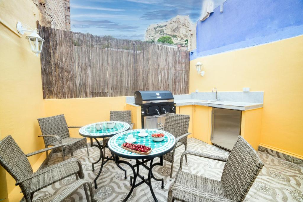 a patio with chairs and a table and a grill at Moonkey - Casa Toledo in Alicante
