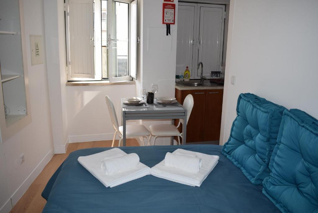 a living room with a blue couch and a table at Studio Station 1 in Coimbra