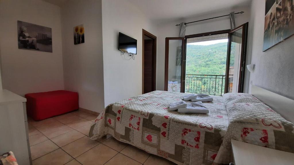 a bedroom with a bed and a large window at Desulo - B&B Perla Del Gennargentu in Desulo