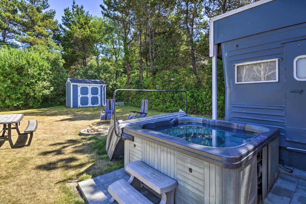 a large hot tub in a yard next to a blue building at Coastal PNW Gem with Hot Tub - Walk to Beach! in Grayland