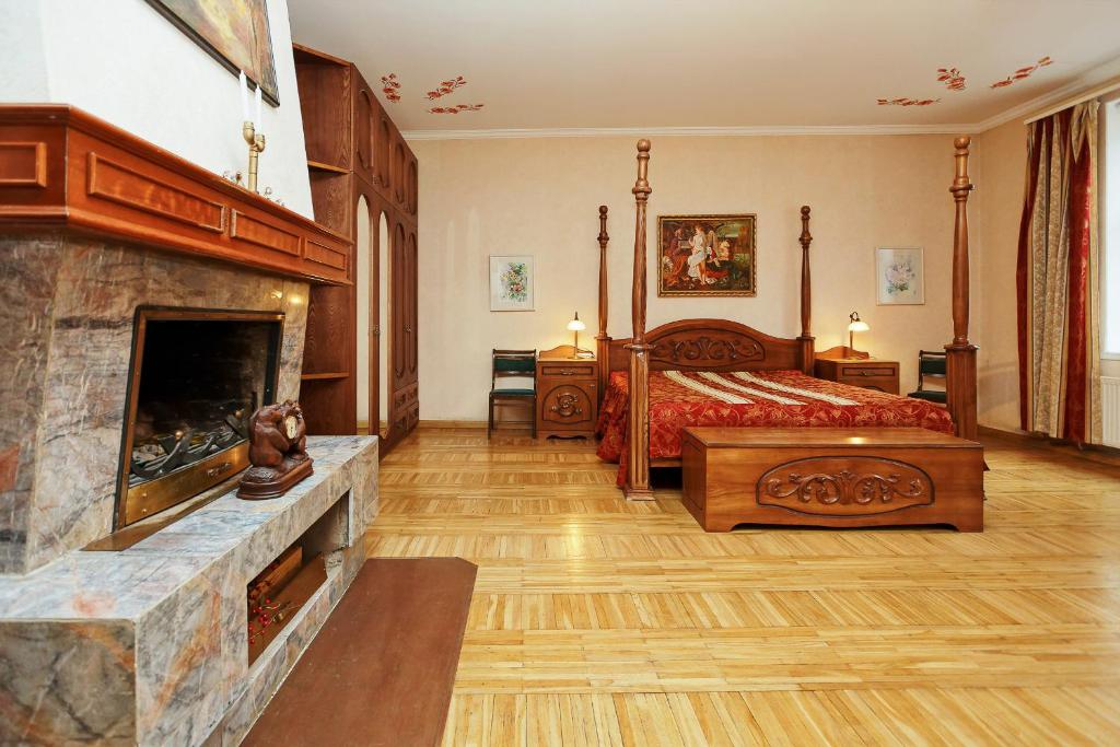 a large bedroom with a bed and a fireplace at Sunny Grand Apartment by Old Town in Rīga