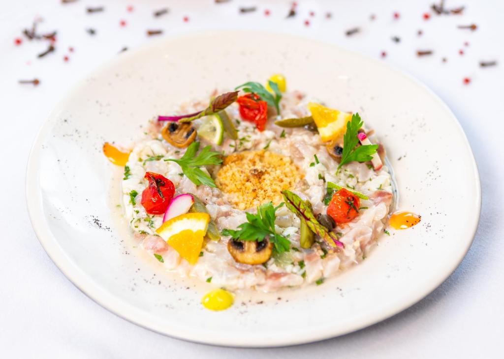 a white plate of food with rice and vegetables at The Residence Tunis in Gammarth
