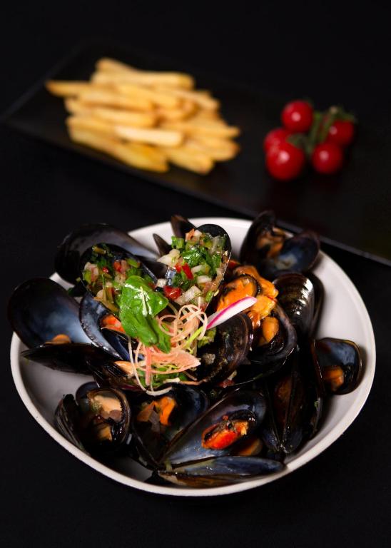 a plate of food with mussels on a table at The Residence Tunis in Gammarth