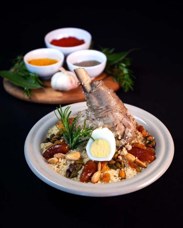a plate of food with a piece of meat on top at The Residence Tunis in Gammarth