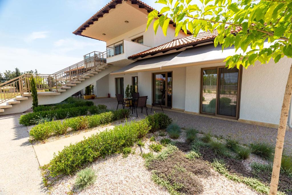 a house with a staircase and a patio at Varkes Suites 1 in Nea Potidaea