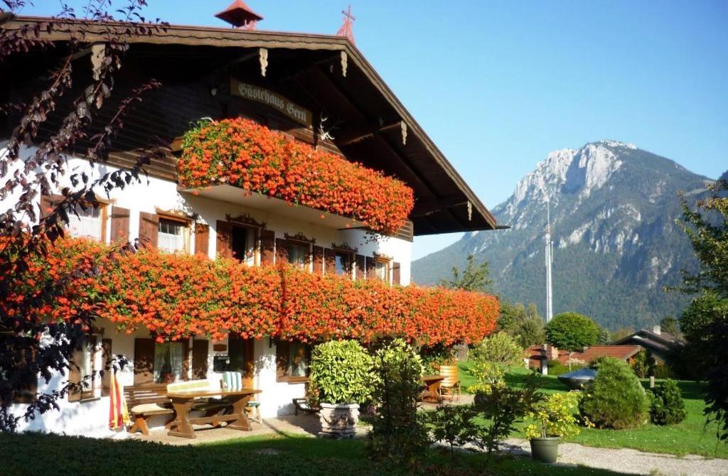 Ein Gebäude mit einem Haufen roter Blumen drauf. in der Unterkunft Gästehaus Gerti in Kiefersfelden