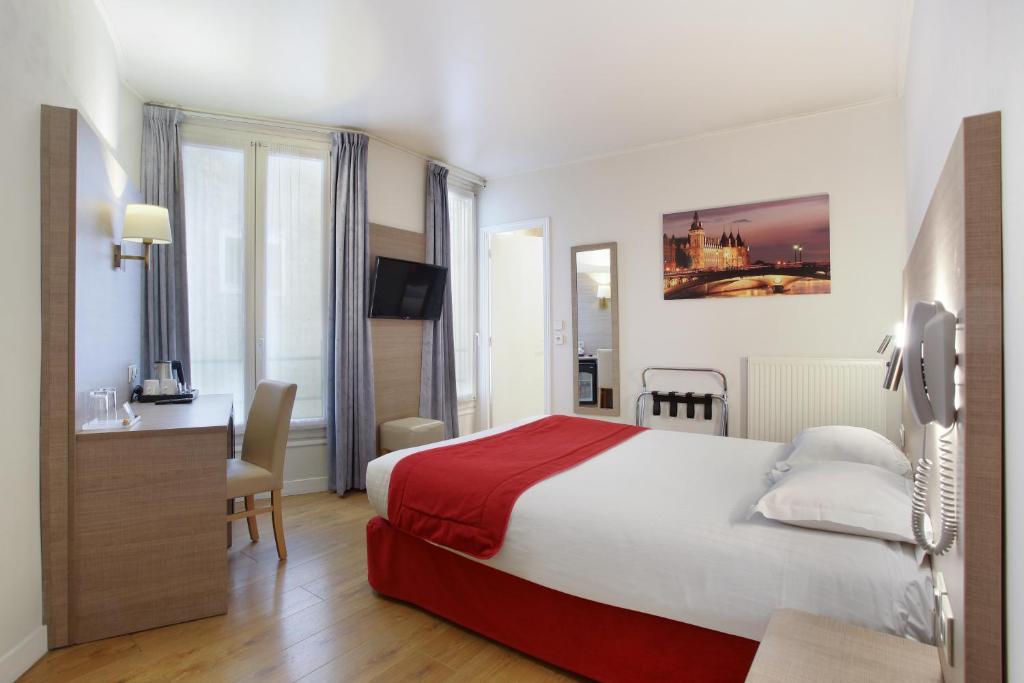 Habitación de hotel con cama grande y escritorio. en Hôtel LUX PICPUS, en París