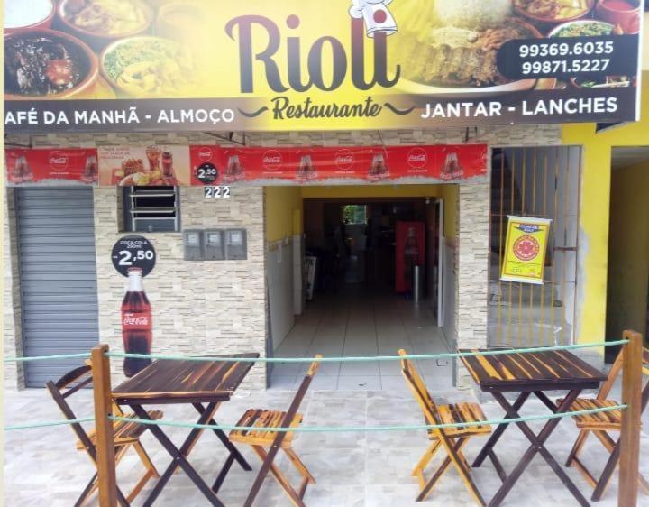 Rioli quarto 2 في كاروارو: طاولتين وكراسي أمام مطعم