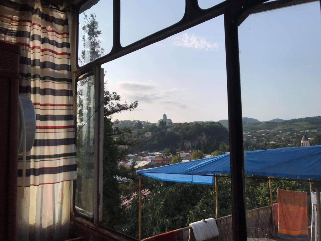 una ventana con vistas a una ciudad a través de ella en Peaceful view en Kutaisi