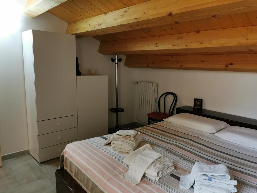 una camera da letto con un letto e asciugamani di La Mansarda Iblea a Palazzolo Acreide
