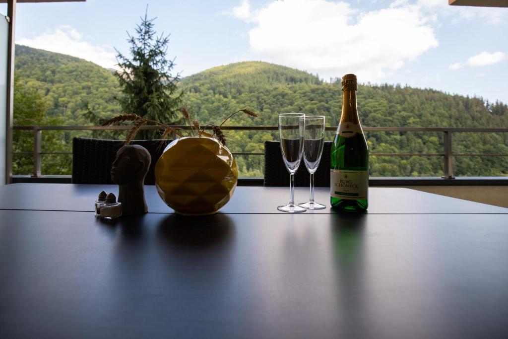 Una botella de vino y dos copas en una mesa. en Apartament Maza, en Sinaia