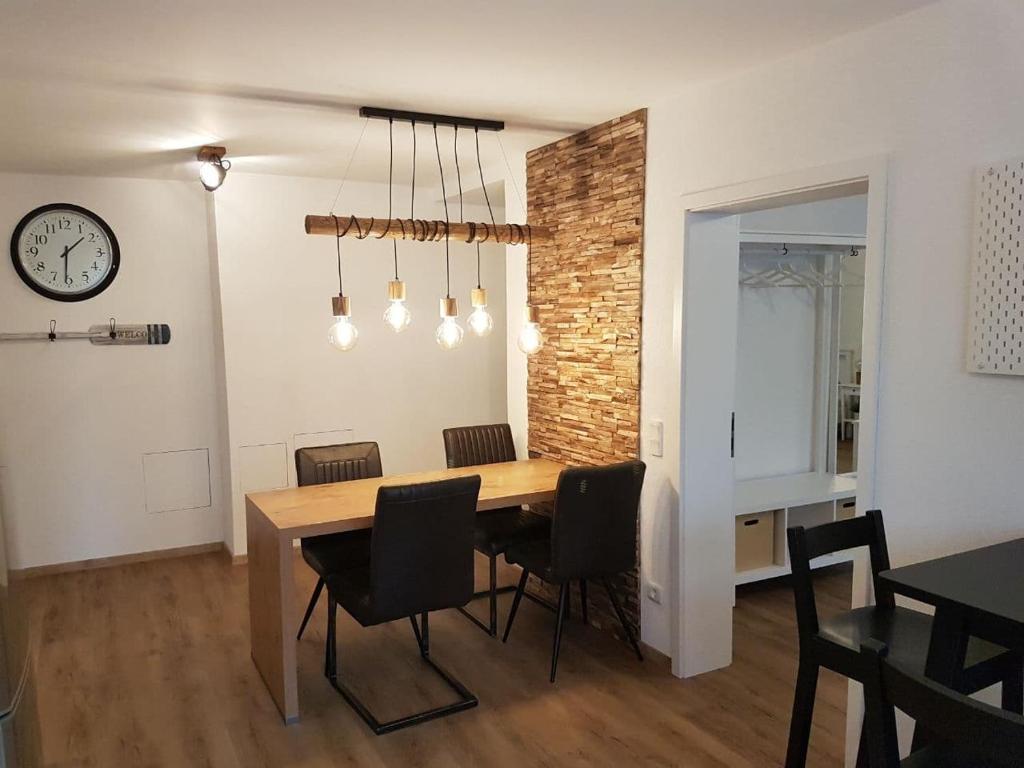 a dining room with a table and chairs and a clock at Jakobs Apartment in Sehnde