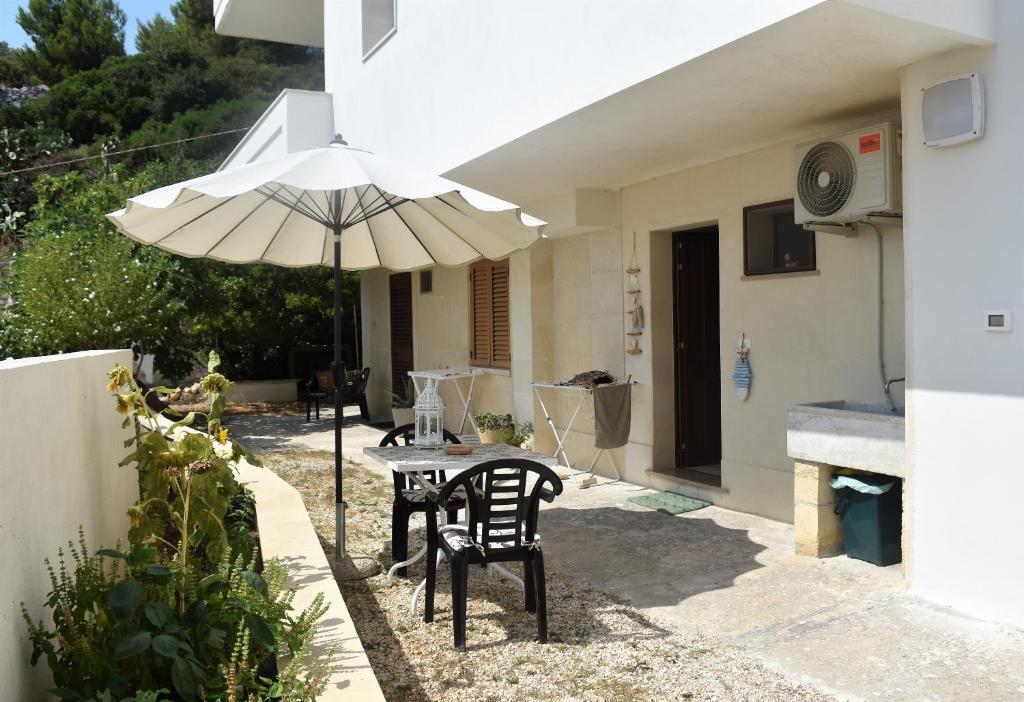 a patio with a table and an umbrella at Casa vacanze Pesce azzurro in Castro di Lecce