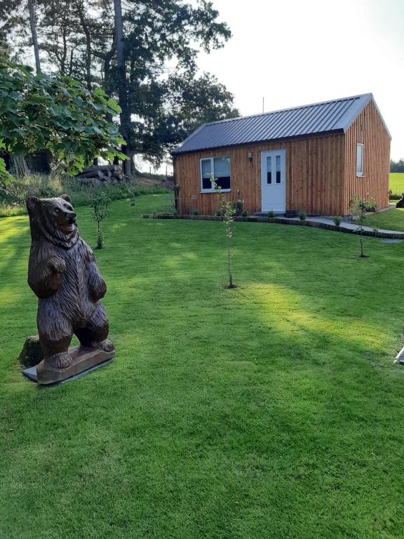 una estatua de un oso en un patio con un edificio en Beautiful studio chalet in the Highland, en Inverness
