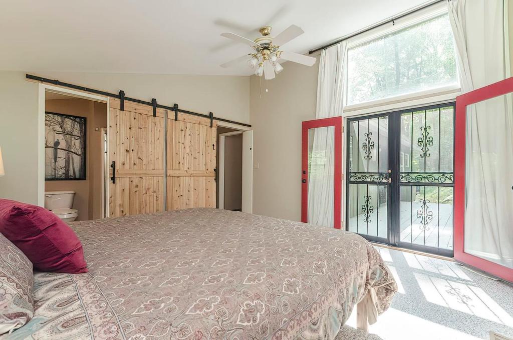 a bedroom with a bed and a ceiling fan at Secluded Oasis w Hot Tub, Screened-in Porch, WiFi! in Berkeley Springs