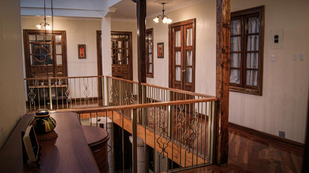 un pasillo con una escalera con puertas de madera y cristal en Hotel La Cierva de San Marcos, en Quito