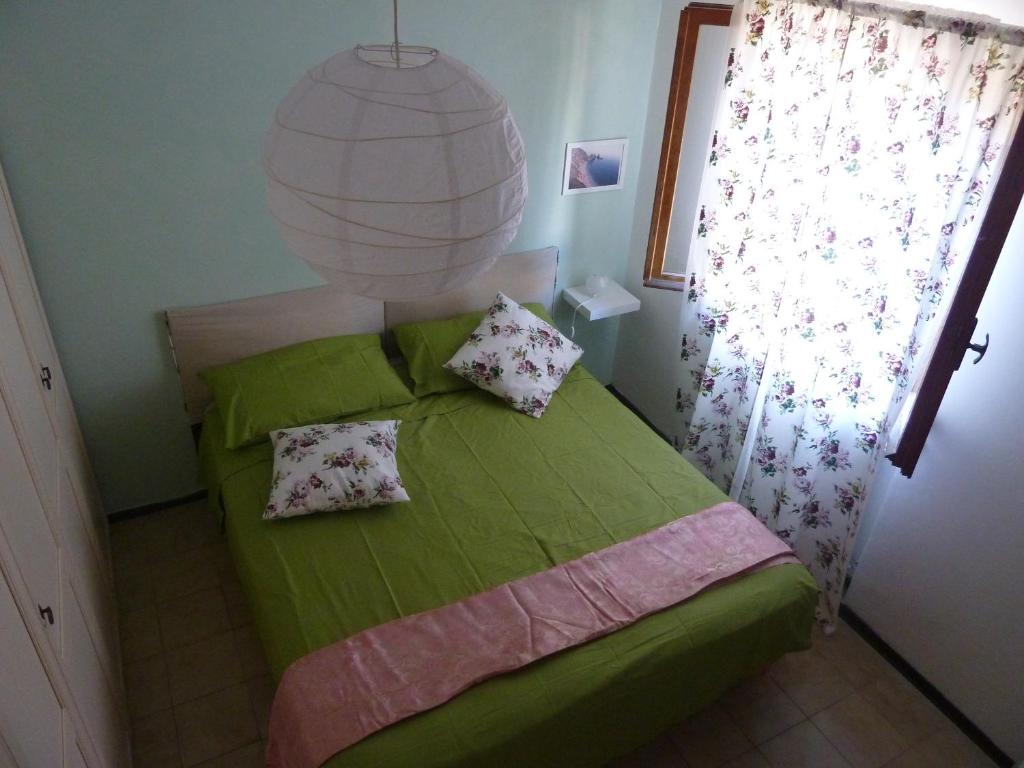 a green bed with two pillows in a bedroom at B & B da Maria in Ancona