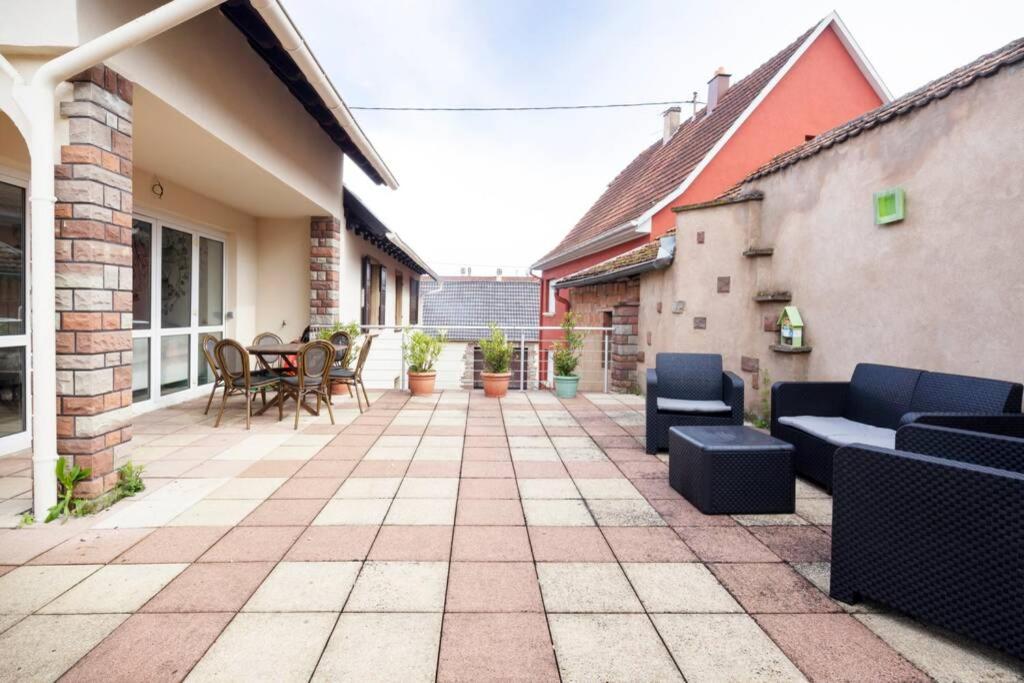 un patio con sofás azules y sillas en una casa en Spacieux Appartement 3 CHBR,,Terrasse,Adapté Bébé en Ettendorf