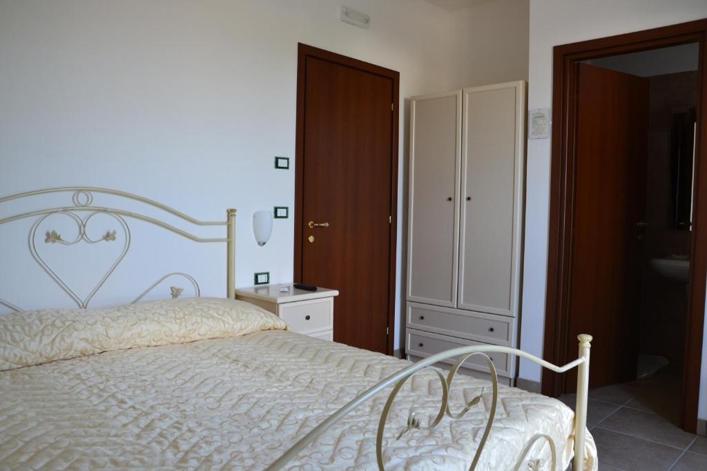 a bedroom with a white bed and a bathroom at Villa Lorenza in Fasano