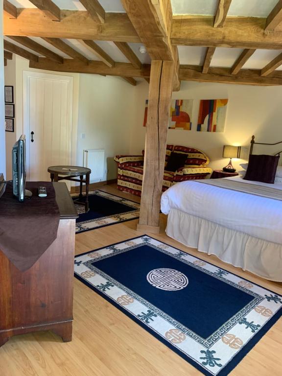 1 dormitorio con cama, escritorio y mesa en Fiddleback Farm, en Wigton