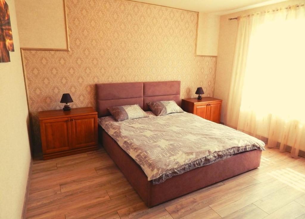 Un dormitorio con una cama con dos mesitas de noche y dos lámparas. en Комфортні Апартаменти біля Фентезі Парка, en Uman