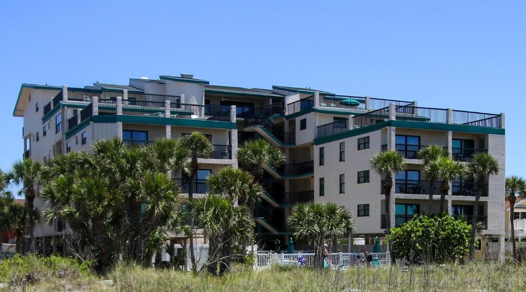 ein Apartmenthaus mit Palmen davor in der Unterkunft All Seasons Vacation Resort by Libertè in St Pete Beach