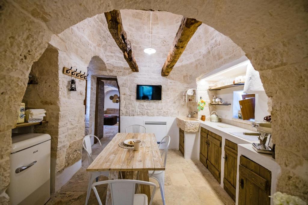 kuchnia z drewnianym stołem w kamiennej kuchni w obiekcie Il Trullo della Rondinina w Alberobello