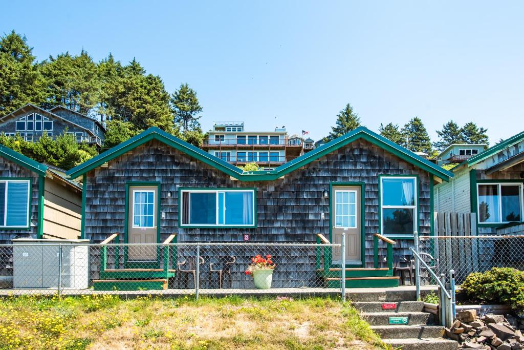 una casa con una valla delante de ella en Oceanside Ocean Front Cabins, en Oceanside