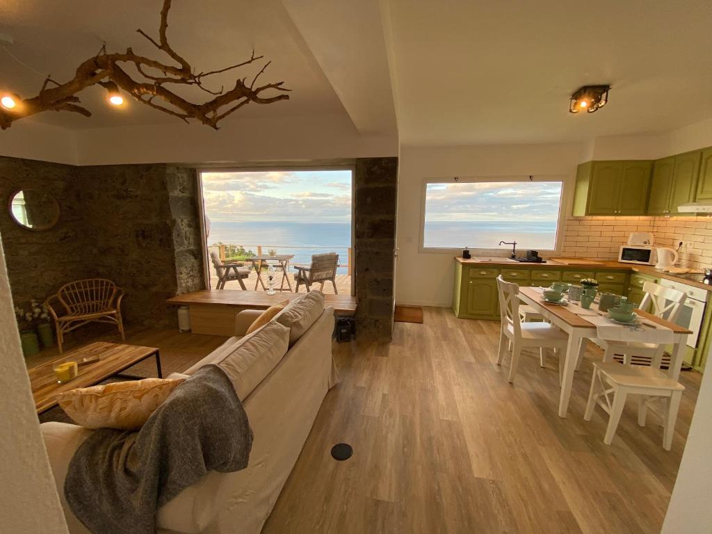 een woonkamer met een bank en een tafel en een keuken bij Craftsman's House in Nordeste
