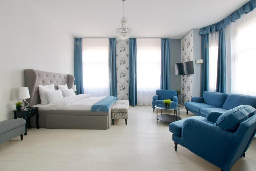 a bedroom with a bed and a couch and chairs at Premium Apartments by Hi5 - Astoria square in Budapest