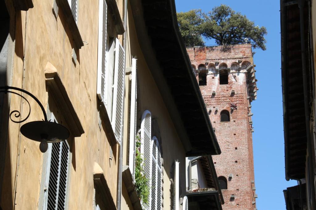 un edificio con una torre dell'orologio sullo sfondo di Residenza Sant' Andrea a Lucca