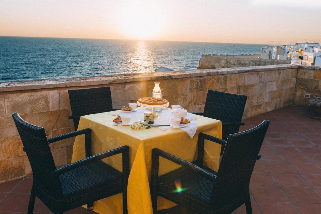 una mesa en un balcón con vistas al océano en B&B Relais Del Senatore en Polignano a Mare