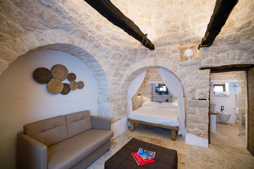 sypialnia z łóżkiem w kamiennej ścianie w obiekcie Il Trullo della Rondinina w Alberobello