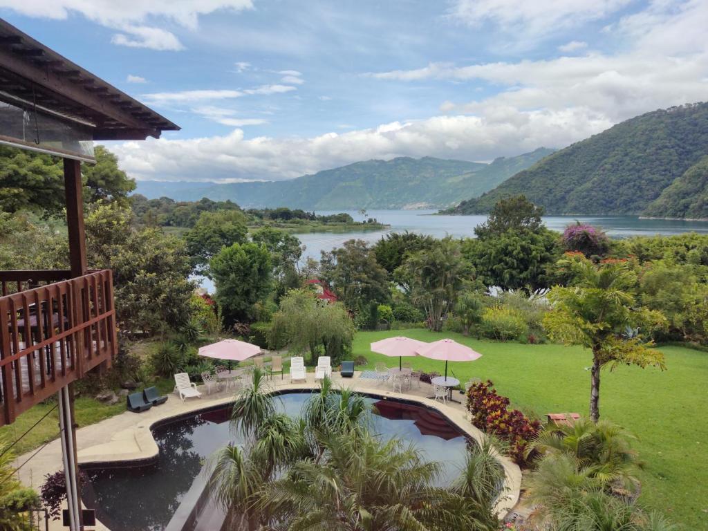 a resort with a pool and a view of a lake at Hotel Toliman in San Lucas Tolimán