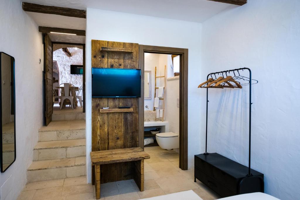 salon z telewizorem i łazienką w obiekcie Il Trullo della Rondinina w Alberobello