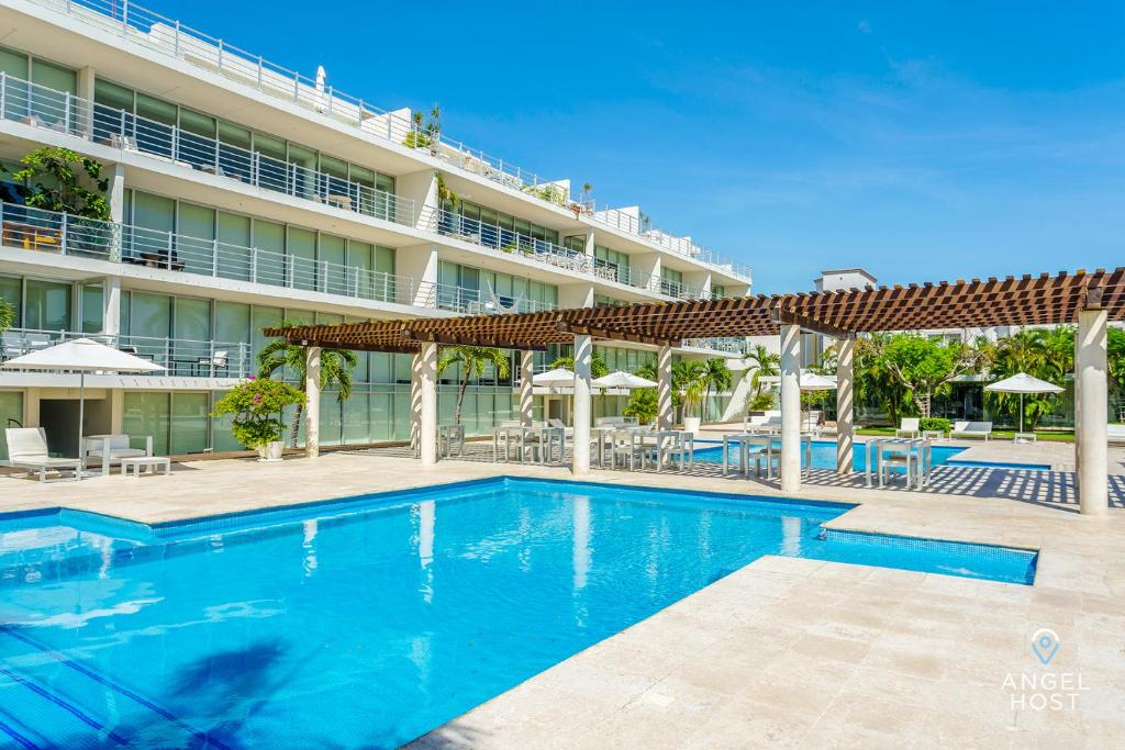 una piscina frente a un hotel en Gorgeous Magia Beachside Condos by Stella Rentals, en Playa del Carmen