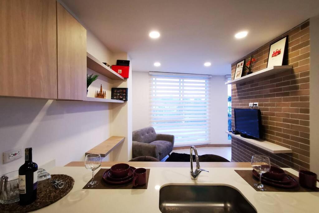 a kitchen with a sink and a living room at Apartamento exclusivo en Manizales-Gran ubicación! in Manizales