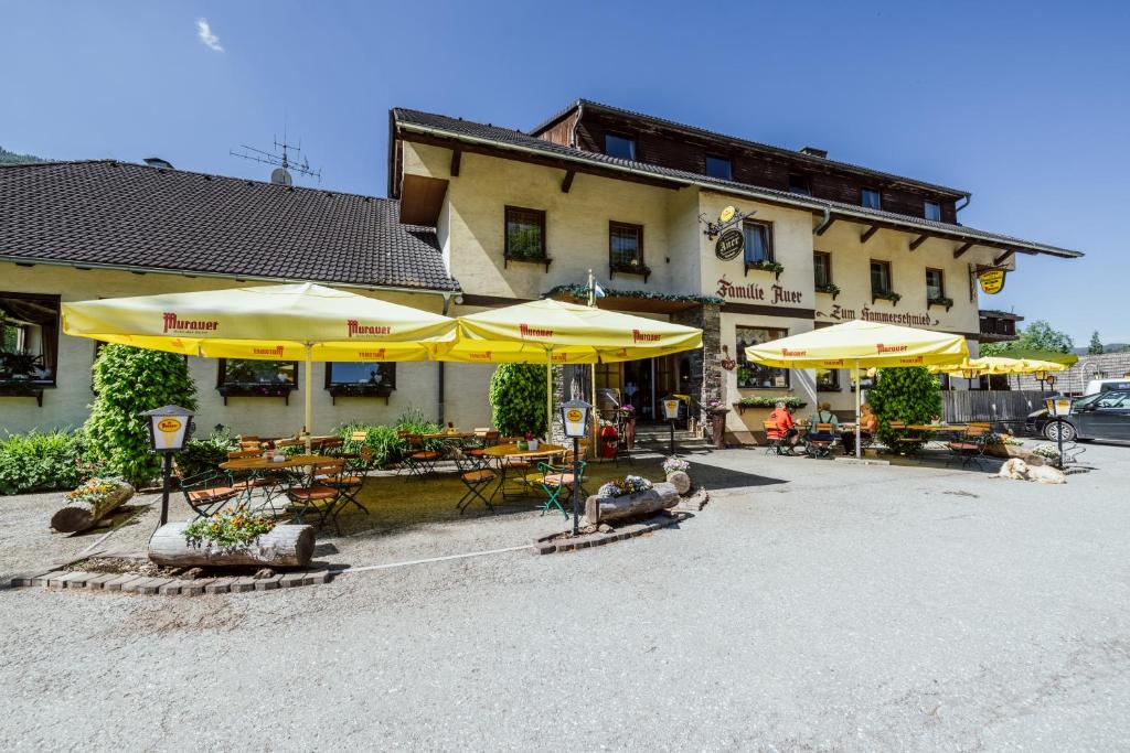 a building with tables and umbrellas in front of it at Landgasthof Zum Hammerschmied in Ranten